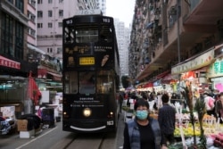 People wear masks as they walk at a marketplace downtown following the outbreak of a new coronavirus, in Hong Kong, China, Feb. 4, 2020.