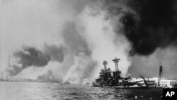 The USS California, right, after being struck by a torpedo and a bomb during the Japanese attack on Pearl Harbor on Dec. 7, 1941.