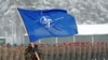Seorang tentara membawa bendera NATO di pangkalan militer Rukla, Lituania 4 Februari 2019. (Foto: REUTERS/Ints Kalnins )