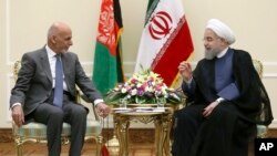 Presiden Iran Hassan Rouhani (kanan) berbicara dengan Ashraf Ghani di kantornya di Teheran, Iran (5/8).