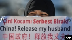 一名维吾尔妇女在中国驻伊斯坦布尔领事馆附近举牌抗议，要求中国政府释放其丈夫。（2021年2月22日）