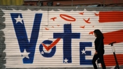 Wata mace tana wucewa gaban alamar zabe a Los Angeles, California.