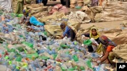 FILE - Pakistani laborers sort through empty bottles at a plastic recycling factory in Hyderabad, Pakistan, April 30, 2023.