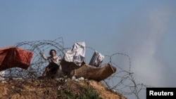 เด็กหญิงชาวปาเลสไตน์ที่พลัดถิ่นจากการสู้รบในกาซ่า ขณะเล่นกับลวดหนามในพื้นที่ราฟาห์ ชายแดนทางตอนใต้ระหว่างฉนวนกาซ่าและอียิปต์ เมื่อ 7 มกราคม 2024 (ที่มา: Reuters)