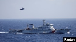 Chinese ship and helicopter are seen during a search and rescue exercise near Qilian Yu subgroup in the Paracel Islands, which is known in China as Xisha Islands, South China Sea, July 14, 2016.