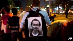 Egyptian activist with poster of slain activist Mohammed el-Gendy, who was killed during the Arab Spring uprising, at rally to withdraw confidence from Egyptian President Mohamed Morsi, Cairo, May 16, 2013.