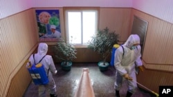 지난 2월 북한 평양에서 방역복을 입은 보건 요원들이 건물 내부를 소독하고 있다.