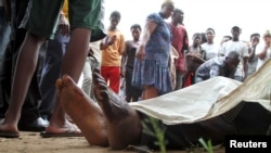 FILE - Residents look at the slain bodies of people killed at the Cibitoke district in Burundi's capital Bujumbura, December 9, 2015. 