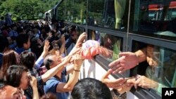 지난 2018년 8월 금강산에서 열린 남북이산가족상봉 행사가 끝난 후 버스에 탄 북측 참가자들이 남측 참가자들과 작별 인사를 나누고 있다.