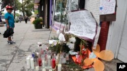 Un jeune garçon regarde des objets déposés en la mémoire d’Eric Garner, vendredi 1 août 2014, dans l'arrondissement de Staten Island dans l’Etat de New York. 