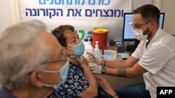 FILE - An Israeli health worker administers a booster shot of a COVID-19 vaccine to a senior citizen at the Clalit Health Service in Jerusalem, Aug. 1, 2021.