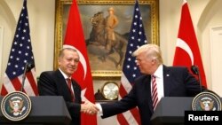 FILE - Turkey's President Recep Tayyip Erdogan, left, shakes hands with U.S President Donald Trump as they give statements to reporters in the Roosevelt Room of the White House in Washington, May 16, 2017.