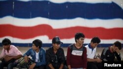Cambodian migrant workers wait for document process as they prepare to migrate back to Cambodia at the Aranyaprathet Police station in Sa Kaew, Thailand, June 15, 2014.