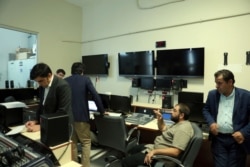 An official for RTUK, left, takes notes in the master control room of IMC TV in Istanbul, Turkey, Oct. 4, 2016.