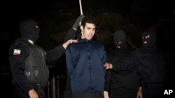 FILE - Iranian policemen prepare to hang a young convict in Tehran, Iran, Jan. 20, 2013. 