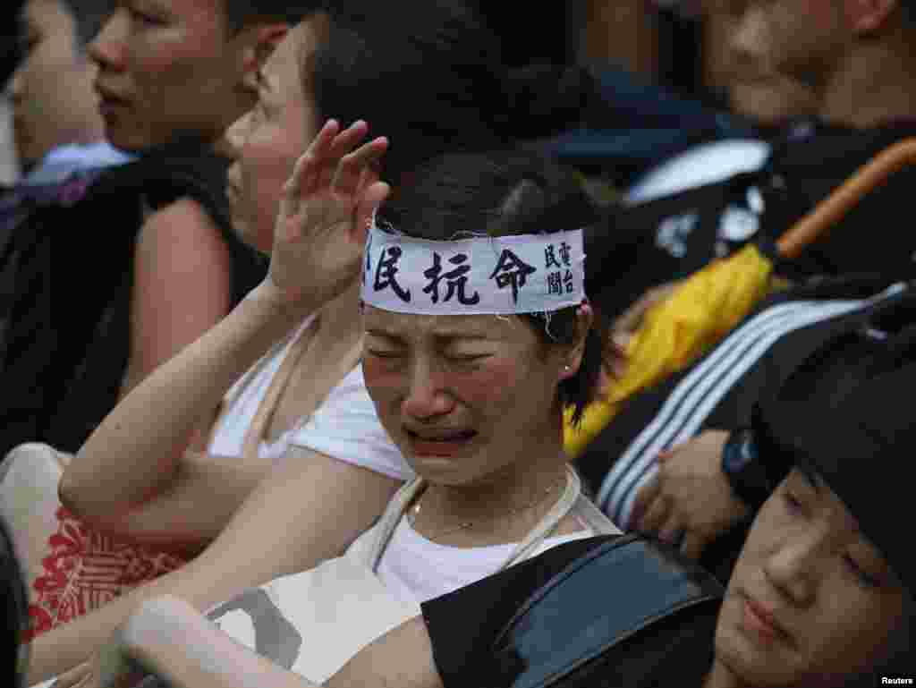 A protester wearing a headband which reads &quot;civil disobedience&quot; cries before being dragged away by&nbsp; police after staying overnight at Hong Kong&#39;s financial district July 2, 2014.
