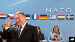 U.S. Secretary of State Mike Pompeo, left, waits for the start of the North Atlantic Council at NATO headquarters in Brussels, April 27, 2018.