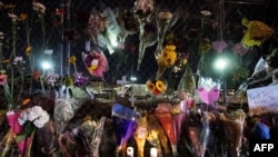 Flowers are laid along the perimeter fence outside a King Soopers grocery store in Boulder, Colorado, March 23, 2021.