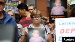 Activists hold placards and chant slogans as they protest outside the offices of the Australian Immigration Department in Sydney, Feb. 4, 2016. A public campaign on behalf of Baby Asah and her parents has prompted the immigration minister to allow the family to remain in the country instead of being sent back to a remote detention camp.
