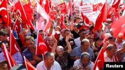 Les partisans de différents partis politiques rassemblés sur la place Taksim brandissent des drapeaux de la Turquie au cours d’un rassemblement organisé par l'opposition principale du Parti républicain du peuple (CHP), à Istanbul, Turquie, 24 juillet 2016. 
