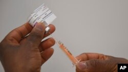 Un vaccin Covid-19 AstraZenaca est préparé dans les installations du NHS Nightingale au Centre Excel de Londres, le lundi 11 janvier 2021. 