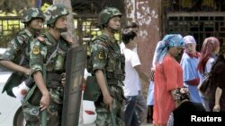 Pasukan keamanan China melakukan patroli di kota Urumqi, Xinjiang (29/6).