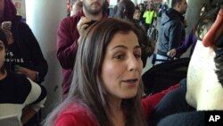 Vahideh Rasekhi, mahasiswi asal Iran yang belajar di program doktoral di Universitas Stony Brook, menyapa teman-teman dan kerabat setelah dibebaskan dari penahanan di Bandara John F. Kennedy, di New York, 29 Januari 2017. (Foto: AP)