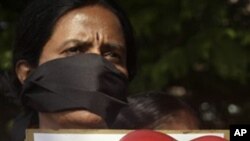 An activist of India's opposition BJP party prepares to burst heart shaped balloon during a protest against Valentine's Day celebrations in Hyderabad, India, Sunday, Feb.13, 2011.