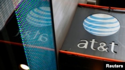 FILE - The signage for an AT&T store is seen in New York, Oct. 29, 2014.
