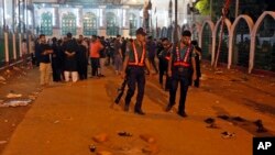 Petugas keamanan Bangladesh memeriksa lokasi ledakan bom di Dhaka, Bangladesh (24/10).