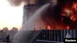 FILE - Members of the Russian emergencies ministry work to extinguish fire at an oil storage tank after an alleged drone attack in the town of Azov, in Russia's Rostov region, June 18, 2024, in this still image taken from video. (Russian Emergencies Ministry/Handout via Reuters)