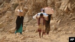 Warga membawa bantuan pangan yang dibagikan oleh WFP di kota Taiz, Yaman (foto: dok). 