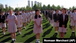 Chinese students gather on a field as they attend the opening ceremony of an international high school in China's Tianjin Municipality. There is growing demand from Chinese parents seeking different paths for their children to college abroad.