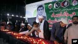 FILE - Members of the Shiite Ulema Council attend a candlelight vigil in Karachi, Pakistan, Oct. 29, 2022, for Pakistani journalist Arshad Sharif, killed by police near Nairobi, Kenya. 
