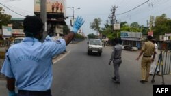 ប៉ូលិស​ និង​អ្នក​ស្ម័គ្រ​ចិត្ត​បញ្ឈប់​រថយន្ត​មួយ​នៅ​កន្លែង​ត្រួតពិនិត្យ​ ក្នុង​ពេល​បិទ​ប្រទេស​ដើម្បី​ទប់ទល់​ការ​រីករាលដាល​នៃ​មេរោគ​កូរ៉ូណា នៅ​ក្នុង​ក្រុង Siliguri កាលពី​ថ្ងៃទី១៣ ខែមេសា ឆ្នាំ២០២០។