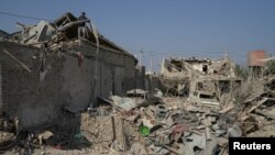 Ali Ibrahimov works on the ruins of his home, which was hit by a rocket, in the city of Ganja, Azerbaijan, Oct. 18, 2020. (Reuters)
