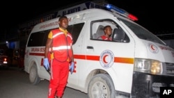 Petugas medis menunggu ambulans setelah serangan bom di sebuah toko es krim di Mogadishu, Somalia, 27 November 2020. Seorang pejabat setempat mengatakan bom bunuh diri itu menewaskan sedikitnya tujuh orang. Kelompok ekstremis al-Shabab telah mengaku bertanggung jawab. (Foto: AP)