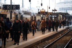 Passengers walk on a platform at the Gare de Lyon railway station in Paris as a strike by French SNCF railway workers and French transportation workers continue, Dec. 6, 2019.
