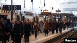Passengers walk on a platform at the Gare de Lyon railway station in Paris as a strike by French SNCF railway workers and French transportation workers continue to protest against French government's pensions reform plans in France, Dec. 6, 2019.