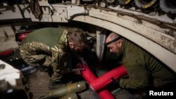 Ukrainian servicemen of the 92nd separate assault brigade load shells in an M109 self-propelled howitzer before firing towards Russian troops, amid Russia's attack on Ukraine, near the town of Vovchansk in Kharkiv region, Ukraine May 20, 2024. 