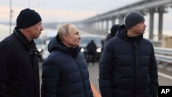ვლადიმირ პუტინი (ცენტრში) ყირიმის ხიდზე. 5 დეკემბერი, 2022 წ. 