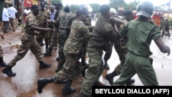 La police guinéenne arrête un manifestant le 28 septembre 2009 devant le plus grand stade de la capitale Conakry. (Photo by SEYLLOU DIALLO / AFP)