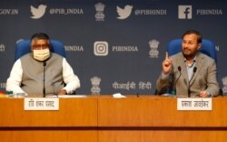 FILE - In this Feb. 25, 2021, photo, India's Information Technology Minister Ravi Shankar Prasad, left, and Information and Broadcasting Minister Prakash Javadekar new regulations for social media companies and digital streaming websites.