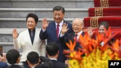 China's President Xi Jinping, second from left, his wife, Peng Liyuan, left, Vietnam's Communist Party General Secretary Nguyen Phu Trong, second from right, and his wife attend a welcome ceremony at the Presidential Palace in Hanoi on Dec. 12, 2023.
