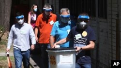 Members of a special election team with a ballot box and voting material leave municipal election commission headquarters on their way to voters who have tested positive for COVID-19 or are in self-isolation, in Skopje, North Macedonia, July 13, 2020.