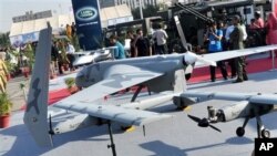 Para pengunjung menyaksikan pameran pesawat tak berawak buatan Pakistan dalam pameran yang diselenggarakan departemen Pertahanan Pakistan di Karachi, Pakistan (15/11). Pakistan secara rahasia memproduksi pesawat tak berawak dalam negeri, karena frustasi dengan penolakan AS untuk menyediakan jenis pesawat ini untuk Pakistan.