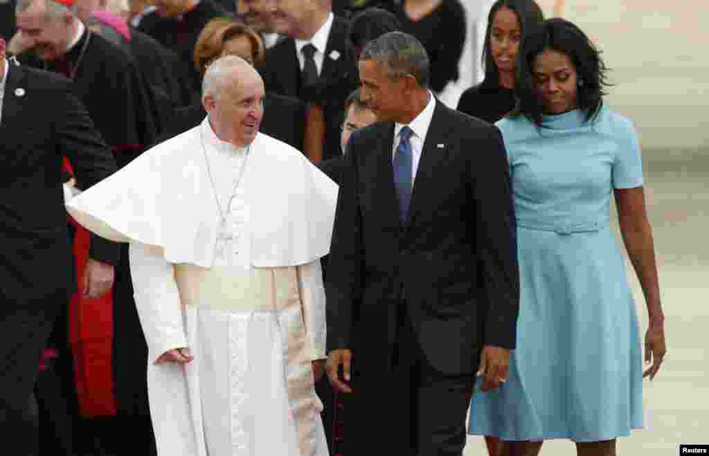 Presiden AS Barack Obama dan istrinya Michelle menyambut Paus Fransiskus saat tiba di Pangkalan Angkatan Udara Andrews, Maryland (22/9). (Reuters/Kevin Lamarque)