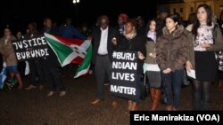 Quelques personnes tiennent des calicots avec mention "justice au Burundi" et "la vie des Burundais d'abord" durant le recueillement devant la Maison Blanche, en mémoire des victimes de la tuerie du weekend dernier dans certains quartiers de Bujumbura, au