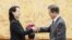លោកស្រី Kim Yo Jong ប្អូនស្រី​មេដឹកនាំ Kim Jong Un ប្រគល់​លិខិត​របស់​លោក Kim Jong Un ទៅ​ឲ្យ​លោក​ប្រធានាធិបតី Moon Jae-in ក្នុង​កិច្ចប្រជុំ​របស់​ពួកគេ​នៅ​ក្នុង​វិមាន​ប្រធានាធិបតី Blue House នៅ​ក្នុង​ក្រុង​សេអ៊ូល កាលពី​ថ្ងៃទី១០ ខែកុម្ភៈ ឆ្នាំ២០១៨។