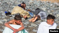 Migrants rest after landing in a dinghy at Aguila beach on the island of Gran Canaria, Spain November 29, 2019. 